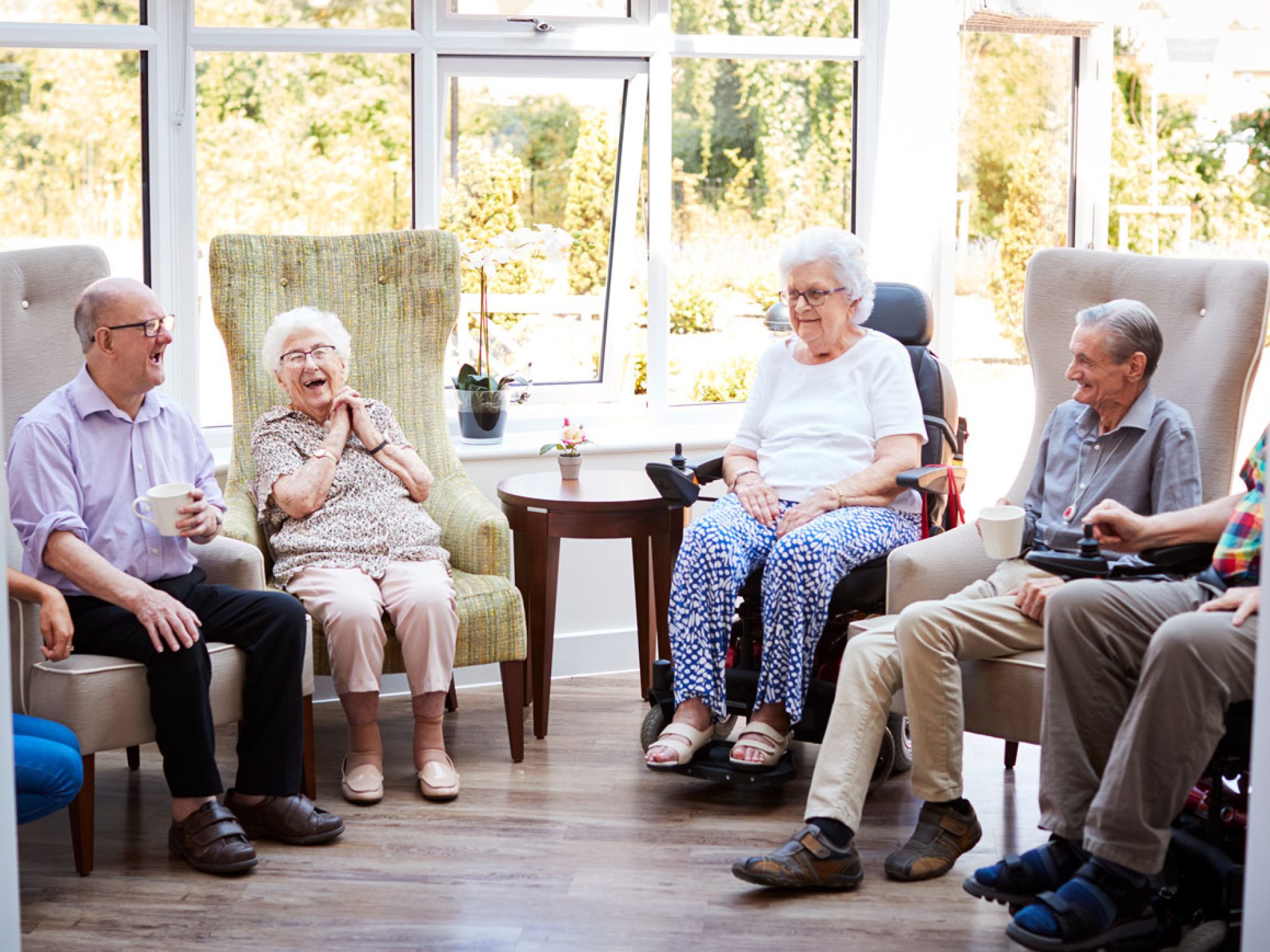 A group of older people sitting together and looking happy