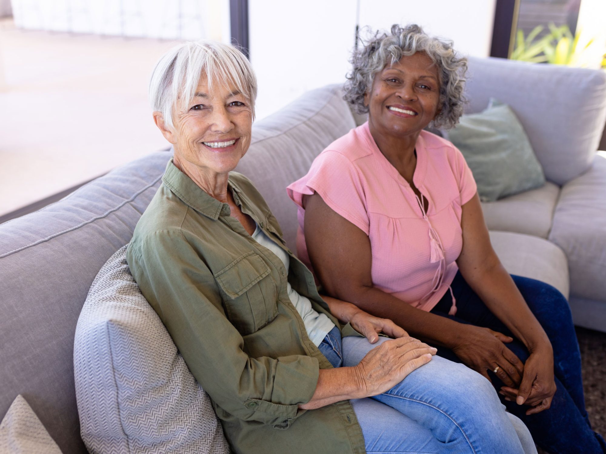 Two older women sitting together on a couch
