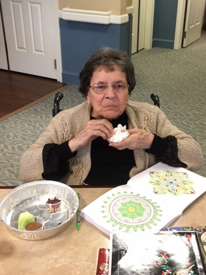A resident of Brudnick Center for Living decorating and eating fruit